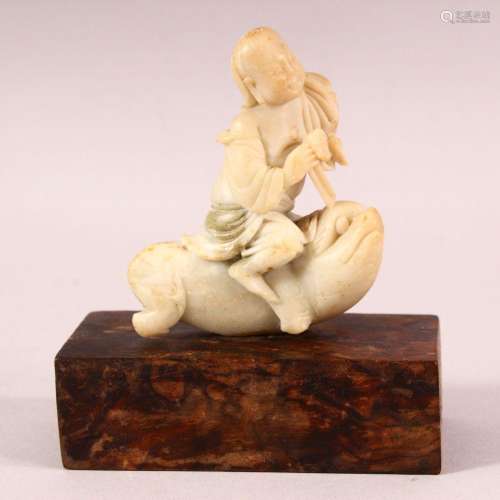 A 19TH CENTURY CHINESE CARVED SOAPSTONE OF A BOY RIDING A BE...