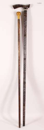 TWO WOODEN INDIAN WALKING STICKS - the larger with white met...