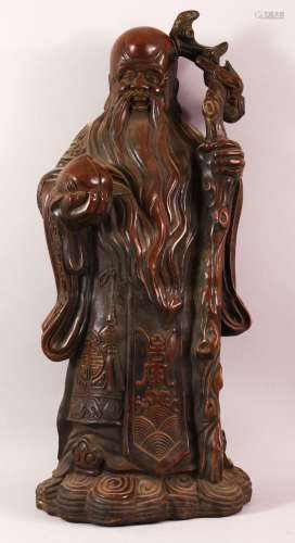 A LARGE CHINESE BRONZE STATUE OF A SAGE holding a peach in o...