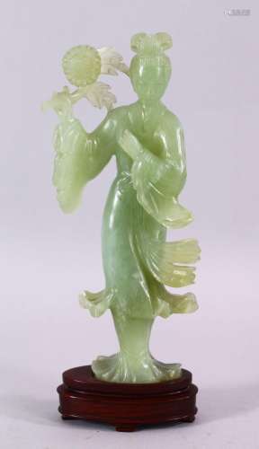 A CHINESE CARVED JADE FIGURE OF GUANYIN, stood holding a bou...
