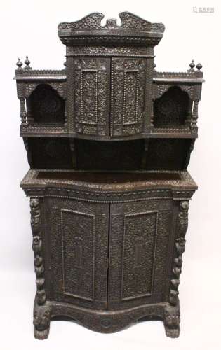A SUPERB CEYLONESE CARVED EBONY CABINET, with broken arch pe...