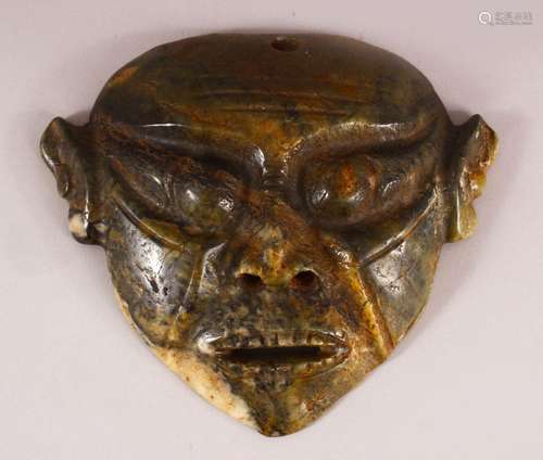 A CHINESE CARVED MOSS JADE HONG SHAN MASK - 20cm wide