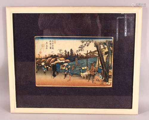 A JAPANESE FRAMED WOOD BLOCK PRINT - depicting figures in vi...