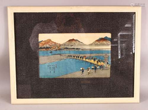 A JAPANESE FRAMED WOOD BLOCK PRINT - depicting figures in vi...