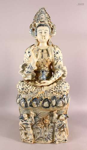 A LARGE CHINESE PORCELAIN FIGURE OF GUANYIN - Seated upon st...