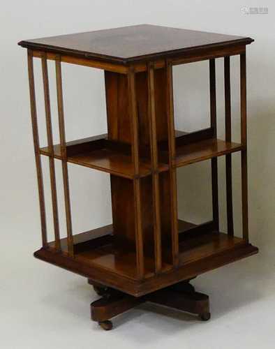 An Edwardian rosewood and marquetry inlaid revolving bookcas...