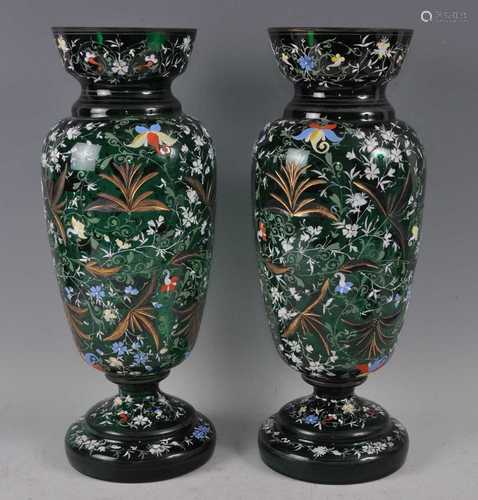 A pair of late Victorian green glass and carved pedestal vas...