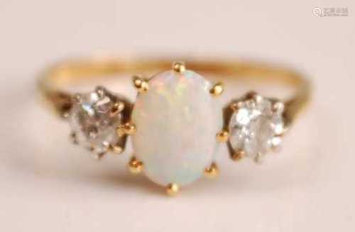 A yellow and white metal, opal and diamond three-stone ring,...