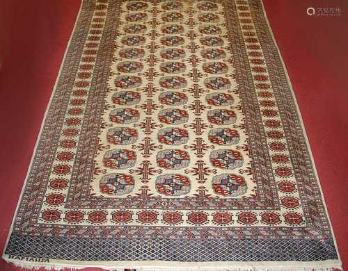 A Persian woollen cream ground Bokhara rug, decorated with t...