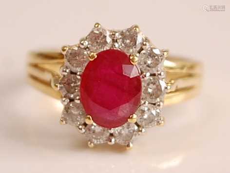 A yellow and white metal, ruby and diamond oval cluster ring...