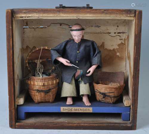 A Chinese softwood cased diorama of a cobbler repairing shoe...