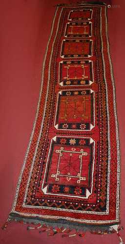 A Turkish woollen hall runner, the red ground decorated with...