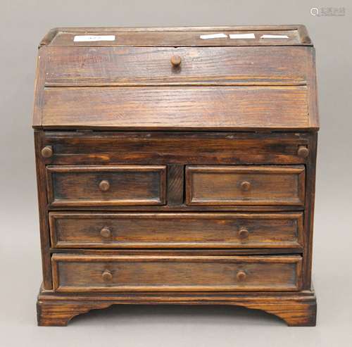 A miniature oak bureau. 25 cm wide.