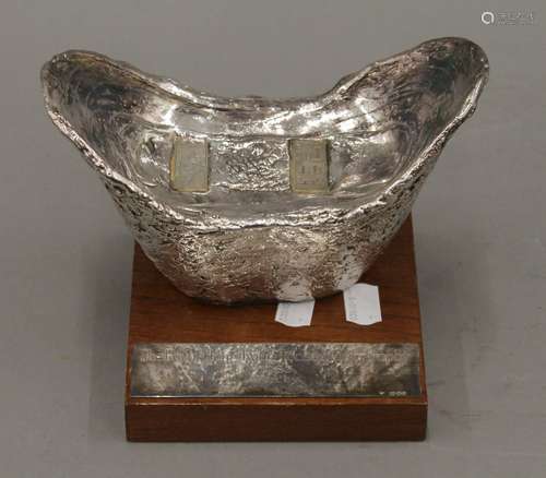 A silver clad Hong Kong Jockey Club trophy mounted on a wood...