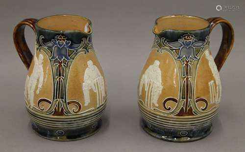 A pair of Doulton Lambeth lemonade jugs decorated with crick...