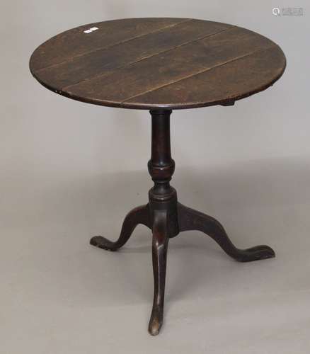 A Georgian oak tilt top tripod table. 70 cm diameter.