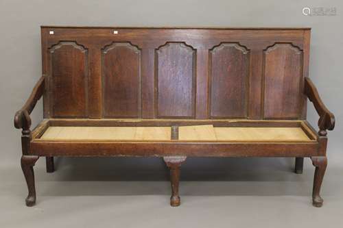 An 18th century oak panelled back settle.