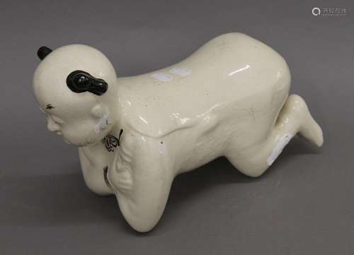 A Chinese porcelain pillow formed as a kneeling boy. 35 cm l...