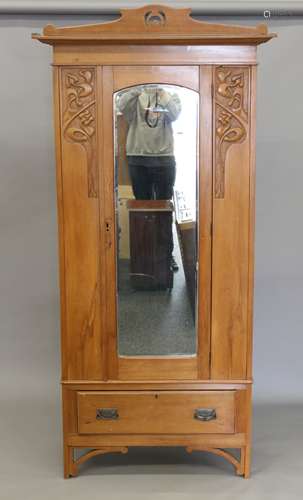 An Art Nouveau satin walnut single mirrored door wardrobe. 9...