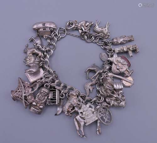 A silver charm bracelet. 20 cm long. 87 grammes total weight...