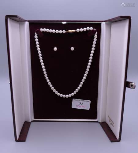 A single strand pearl necklace with matching earrings. Neckl...