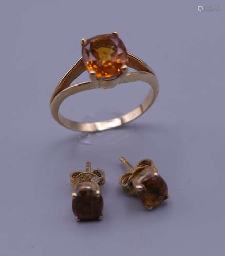 An 18 ct gold stone set ring with matching earrings. Ring si...