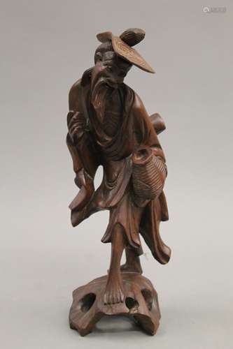 An Oriental carved wooden figure of an elderly gentleman. 28...