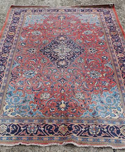 A large Iranian red ground wool rug. 330 x 222 cm.