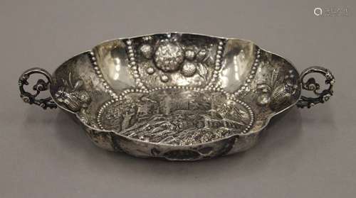 An Augsburg twin handled silver dish, heavily decorated with...