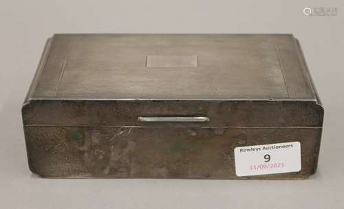 A silver cigarette box. 17 cm wide. 509 grammes total weight...