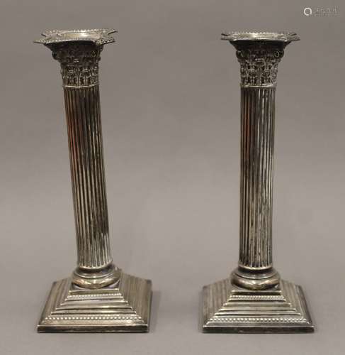 A pair of silver Corinthian column candlesticks. 23 cm high....