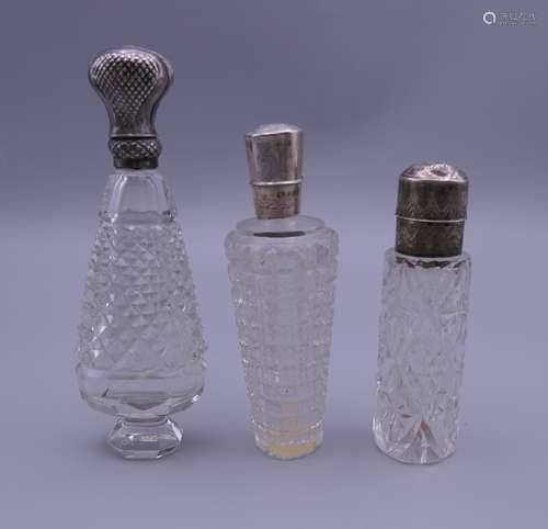 Three French silver topped scent bottles. 8 cm high, 8.75 cm...