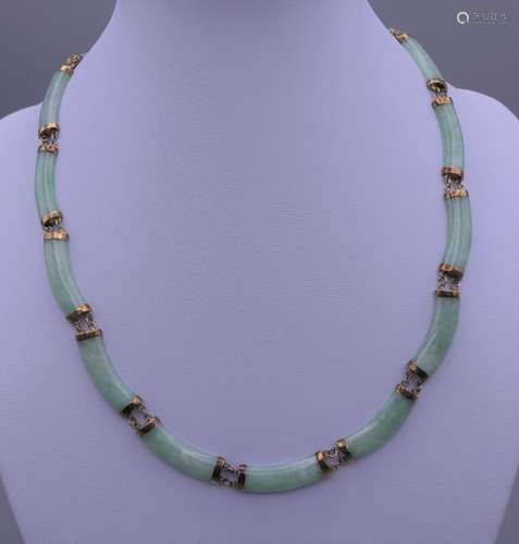 A gold and jade necklace. 42 cm long.