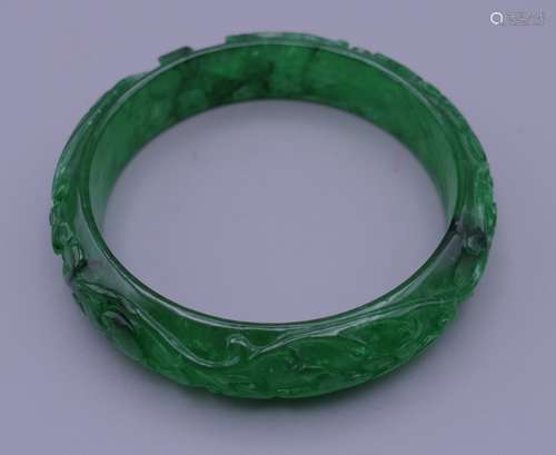 A carved jade bangle. 6 cm interior diameter.