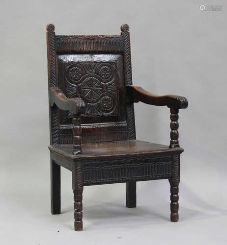 A 17th century oak Wainscot armchair, the carved panel back ...