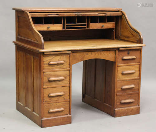 An early 20th century oak roll-top desk, the tambour shutter...