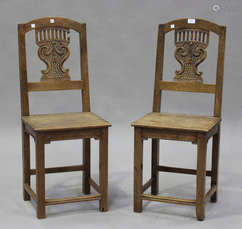 A pair of late 19th century French oak hall chairs with carv...