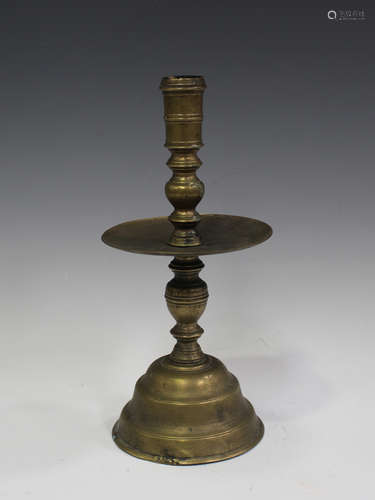 A 17th century style brass candlestick with turned knop stem...