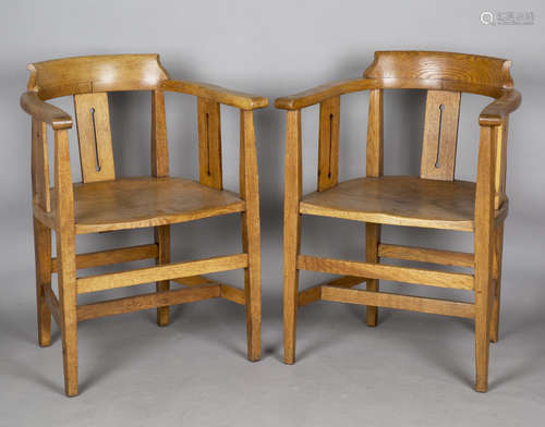 A pair of Edwardian Arts and Crafts oak tub back elbow chair...