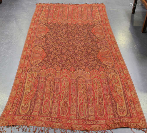 A large woven wool Paisley shawl, worked with a central fiel...