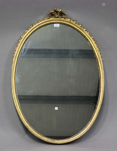 An early 20th century oval giltwood wall mirror with ribbon ...