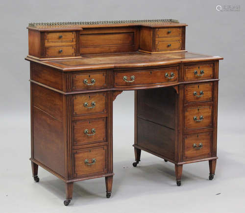 An Edwardian walnut break-bowfront desk by Maple & Co, fitte...