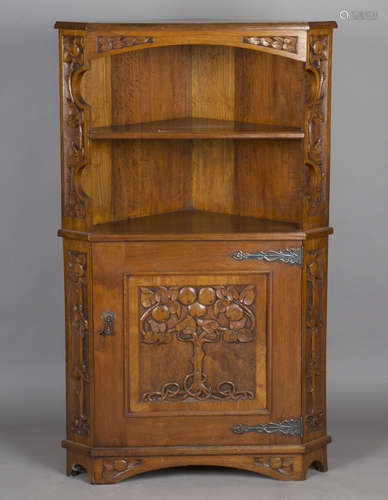 An early 20th century Arts and Crafts walnut corner cabinet,...