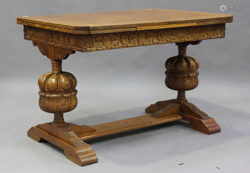 A George V golden oak draw-leaf dining table, raised on carv...