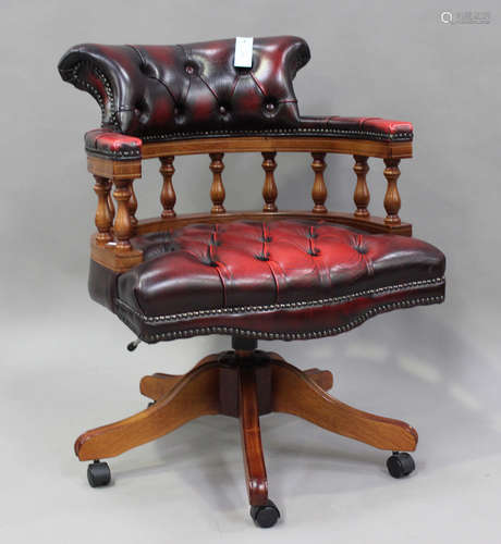 A 20th century reproduction mahogany revolving tub back desk...