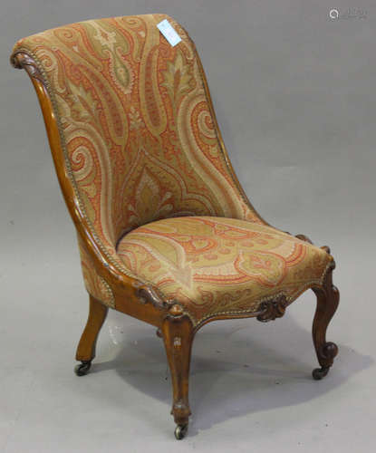 A mid-Victorian walnut framed salon chair, covered in a wove...