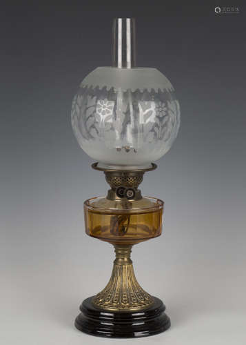 A late Victorian gilt brass and amber glass table oil lamp, ...