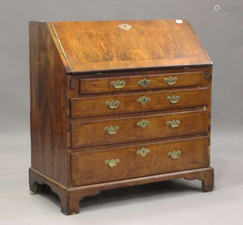 A George I walnut bureau, the fall front revealing a fitted ...