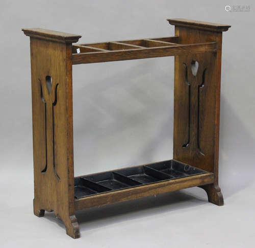 An Edwardian Arts and Crafts oak four-division stick stand, ...