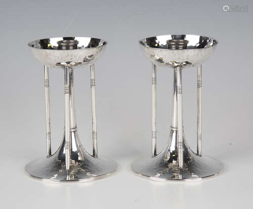 A pair of Arts and Crafts style plated metal candlesticks wi...